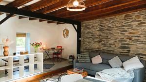 a living room with a couch and a stone wall at L'Échappée en Sandales in La Gacilly