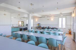 a large room with tables and blue chairs at HI Ofir – Pousada de Juventude in Esposende