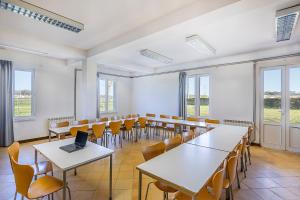 an empty room with tables and chairs and a laptop at HI Ofir – Pousada de Juventude in Esposende +48 photos