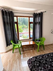 a bedroom with a bed and two chairs and a window at Barot Palace in Barot 