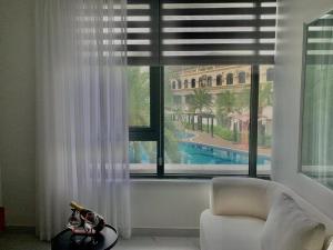 a living room with a window with a view of a pool at Sunrise Apartments in Xóm Niêm