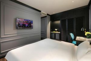 a bedroom with a bed and a tv on the wall at Casa Dos Príncipes Hotel & Spa in Hanoi