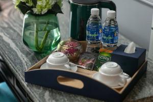a tray with cups and bottles of water on a table at Casa Dos Príncipes Hotel & Spa in Hanoi
