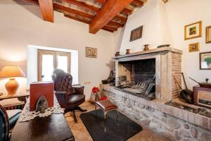 a living room with a fireplace and a chair at Collazzone - "Il Tramonto" casale con piscina in Collazzone