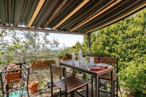 a table and chairs on a patio with a view at Collazzone - "Il Tramonto" casale con piscina in Collazzone