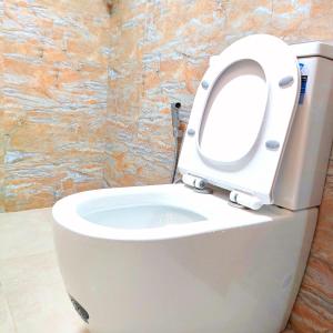 a white toilet with the seat up in a bathroom at Samson & Ruby Villa in Weligama