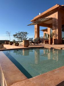 a swimming pool in front of a house at Villa Kela Serene in Marrakesh