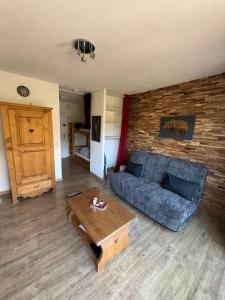 a living room with a blue couch and a table at Dove house in Barcelonnette
