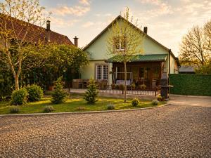 a green house with a porch on a street at Petrović Garden in Inđija