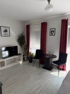 a living room with a tv and a table and chairs at Apartament Helsinki in Pniewy