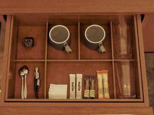 a wooden cabinet with books and cups and books at illi Hotels Lume Shibuya in Tokyo +28 photos