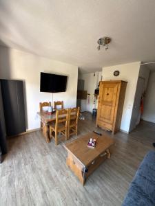 a living room with a table and a tv at Dove house in Barcelonnette