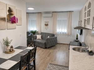 a kitchen and living room with a couch and a table at Petrović Garden in Inđija