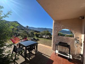 a table and chairs on a patio with a view at Les Marines, Castello Rosso vue mer - Accès plage à pied in Casaglione