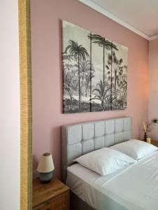 a bedroom with a bed and a picture of palm trees at Blue Sky Apartments Pythagorion in Pythagoreio