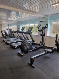 a gym with a row of tread machines in a room at Sands Holiday Chalet Dog friendly, free wifi, swimming pool and new gym passes and free club entry in Scratby +27 photos