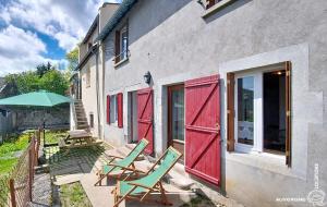 a patio with two lawn chairs and an umbrella at Aux Marches du Château in Murol