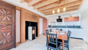 a kitchen and dining room with a table and chairs at Aux Marches du Château in Murol
