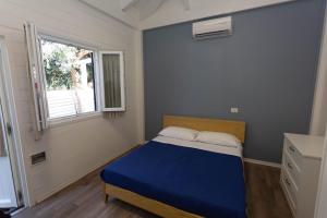 a small bedroom with a blue bed and a window at Aquarius Policoro in Policoro