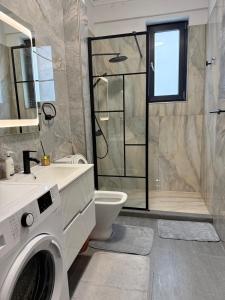a bathroom with a washing machine and a shower at Cozy Crib 2 in Mamaia Sat/Năvodari +9 photos