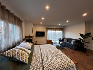 a bedroom with a large bed and a couch at L'Attrape-Rêves in La Gaude