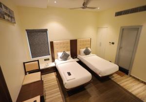 a bedroom with two beds and a chalkboard on the wall at YAR INN CENTRAL in Vijayawāda +25 photos