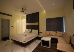 a bedroom with a large white bed and a table at YAR INN CENTRAL in Vijayawāda