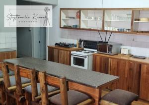 a kitchen with a table with chairs and a microwave at Steytlerville Karoo Backpackers in Steytlerville