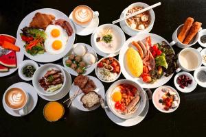 a table topped with plates of food and bowls of food at Grande Centre Point Hotel Terminal21 in Bangkok