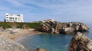a large white building on top of a rocky beach at Casa das Marés 3 in Baleal +17 photos