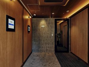 a hallway in a building with wooden walls and a door at illi Hotels Lume Shibuya in Tokyo