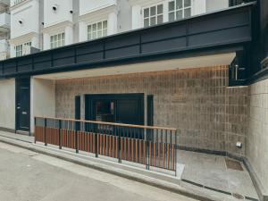 a brick building with a black door and a fence at illi Hotels Lume Shibuya in Tokyo