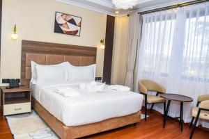a hotel room with a bed and a table and chairs at Sebai Luxury Suites in Naivasha