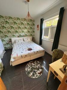 a small bedroom with a bed and a table at L'enjo'Leuze in Winée