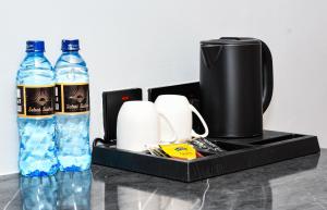 a tray with a coffee pot and two bottles of water at Sebai Luxury Suites in Naivasha +18 photos
