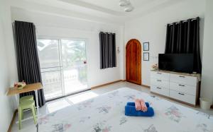 a living room with a large window and a tv at Baan Iris Salaya in Salaya +44 photos