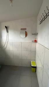 a white bathroom with a mirror and a sink at Cabin Dieng Db in Diyeng