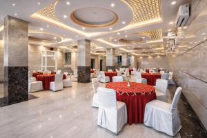 a banquet hall with red and white tables and chairs at Hotel Viva Palace By OPO Delhi Airport in New Delhi
