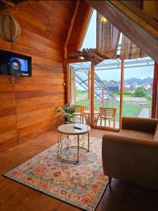 a living room with a couch and a table at Cabin Dieng Db in Diyeng
