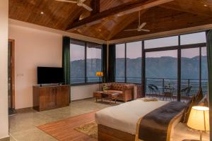 a bedroom with a bed and a flat screen tv at Maverick Heights in Kasauli