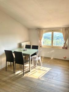 a dining room with a table and chairs and a window at Le Mongolfiere in Mondovì