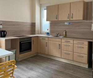 a kitchen with wooden cabinets and a sink and a stove at Pension Highway - Löhne Löhner Straße 111 in Löhne