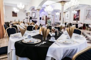 a set of tables in a room with chandeliers at Hotel Komfort Inn - Dwór Hubertus in Piekary Śląskie