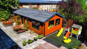 an orange house with a playground and a slide at Hotel Komfort Inn - Dwór Hubertus in Piekary Śląskie