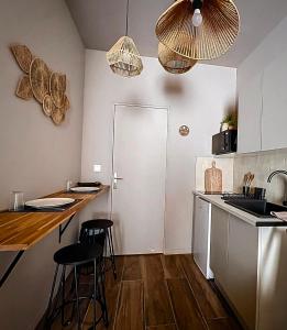 a kitchen with a counter and stools in a room at Expérience Balinaise à Amiens in Amiens