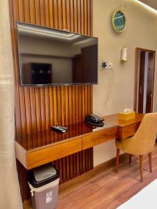 a wooden desk with a television on a wall at Sheraton Royal Sea View in Alexandria