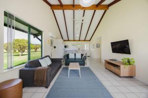 a living room with a couch and a tv at Surfside Ocean Beach Denmark Holiday Accommodation in Denmark