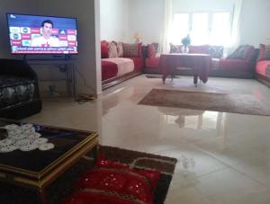 a living room with a couch and a tv at Apartment Centre Hamria in Meknès