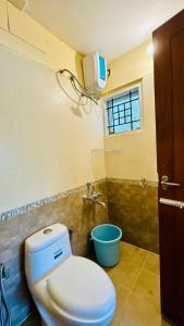 a bathroom with a toilet and a blue bucket at Hotel SK Temple View in Tiruvannāmalai
