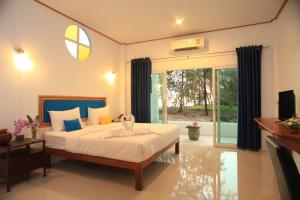 a bedroom with a large bed and a table at Barn Talaepu Resort in Ban Suan Khat